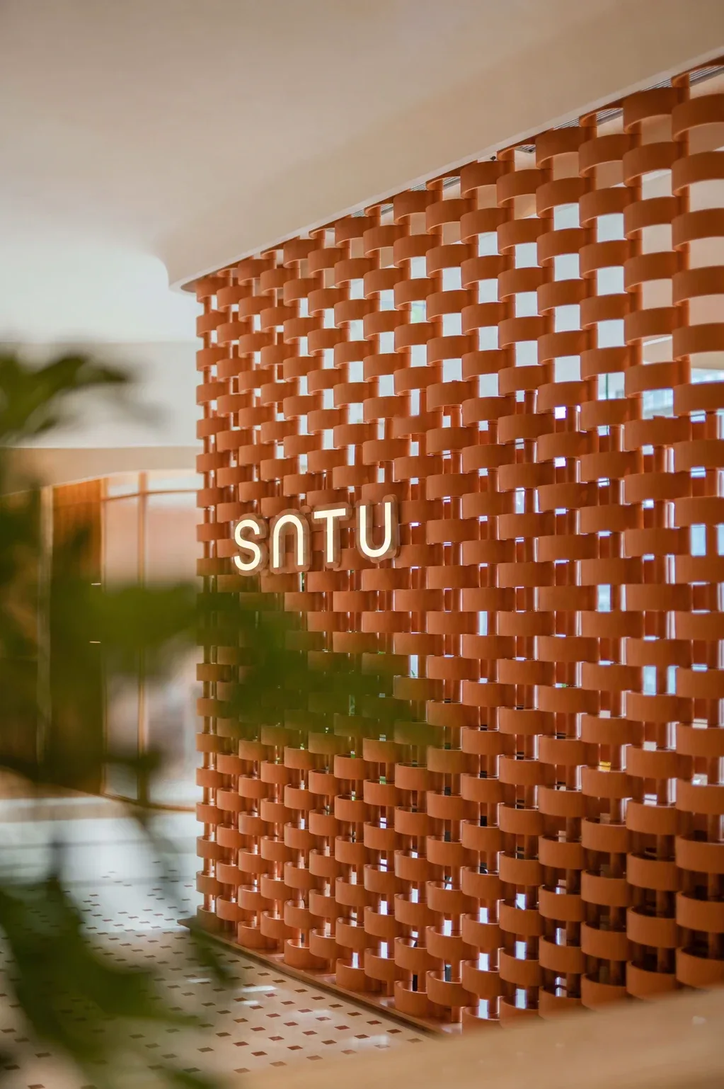 雕塑感陶土屏風中的 SATU 品牌標誌